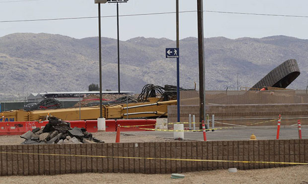 A toppled crane that was being used in the construction of the Sky Train guideway system lies it's ...
