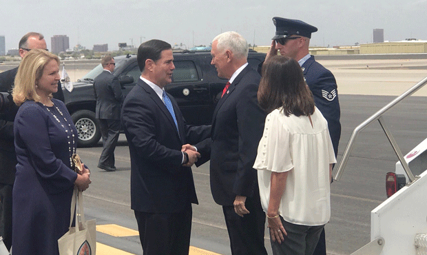 Arizona Gov. Doug Ducey greets then-Vice President Mike Pence at Phoenix Sky Harbor International A...