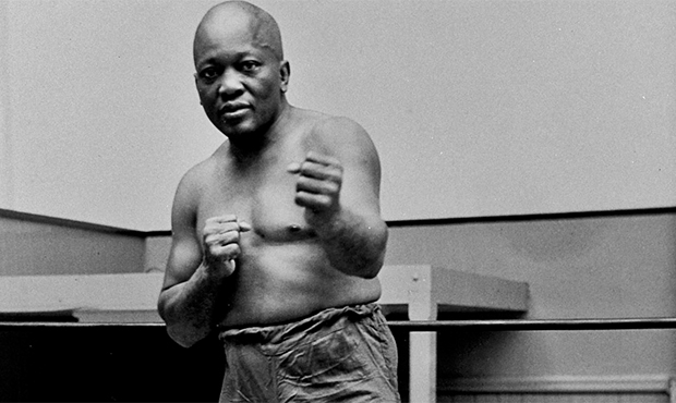 FILE - In this 1932 file photo, boxer Jack Johnson, the first black world heavyweight champion, pos...