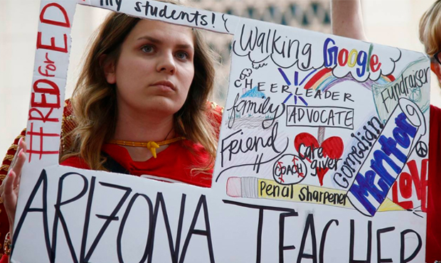 Teacher Taylor Dutro listens as protest organizers announce Arizona teachers intentions to go back ...