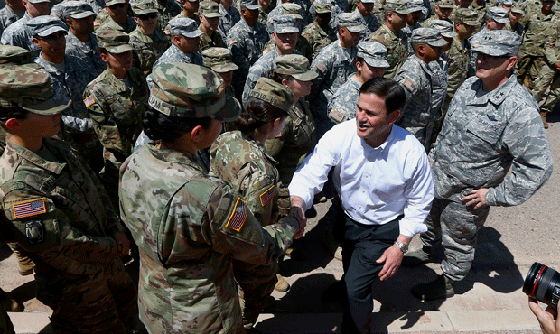 Arizona's Republican Gov. Doug Ducey, front right, meets with Arizona National Guard soldiers prior...