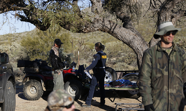 Officer Laura Orscheln with the Arizona Game & Fish Department checks a group of javelina hunters n...