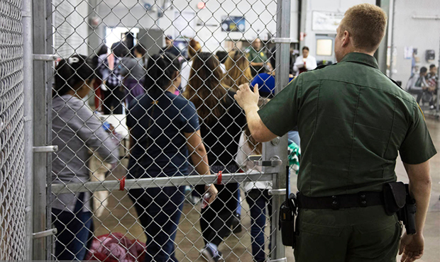 In this photo provided by U.S. Customs and Border Protection, a U.S. Border Patrol agent watches as...
