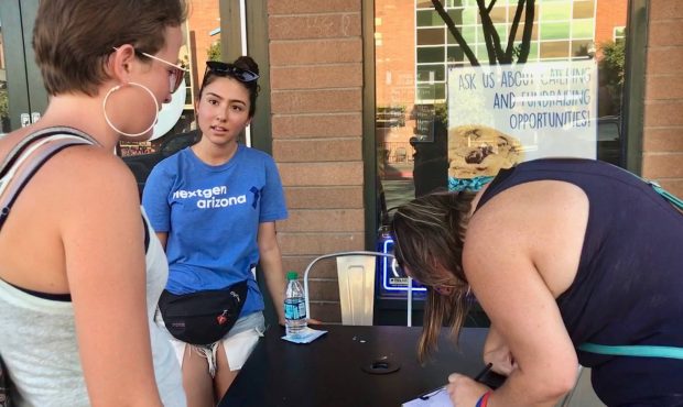 Audry Ruiz (center) spent several hours last week walking up and down Tempe's Mill Avenue registeri...