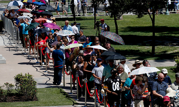 Members of the public carry umbrellas as they line up to pay their respects to Sen. John McCain dur...