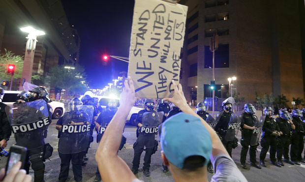 Protesters yell after Phoenix police used tear gas outside the Phoenix Convention Center, Tuesday, ...