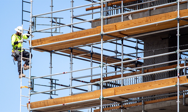 A construction worker on scaffolding for a new apartment project in downtown Phoenix. A new report ...
