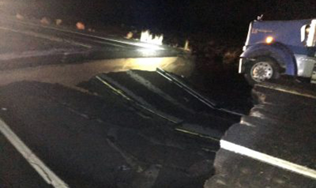 This photo provided by the Arizona Department of Public Safety shows a semi truck stuck in a large ...