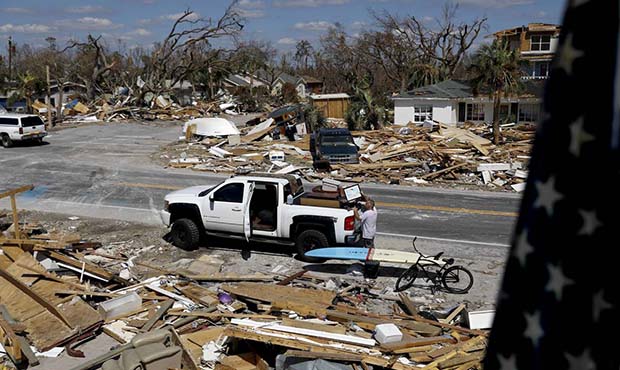William Johnson helps pack up a friend's belongings as he returns to his damaged home from hurrican...
