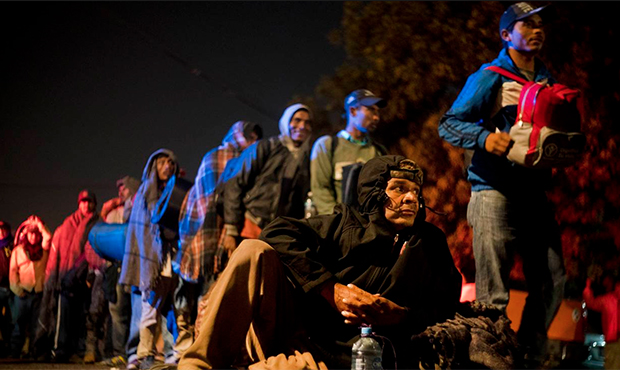 Honduran migrant Alfredo Lopez, part of the Central American migrants, rests on the ground waiting ...
