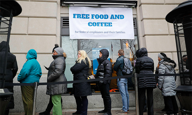 People wait in line at Chef Jose Andres' World Central Kitchen for free meals to workers effected b...