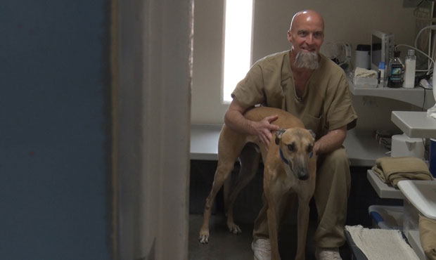 Saguaro Correctional Facility inmate David Parker gives his trainee dog Crusher a few pats. (Cronki...