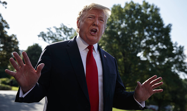 President Donald Trump talks with reporters before departing on Marine One for the Air Force Academ...