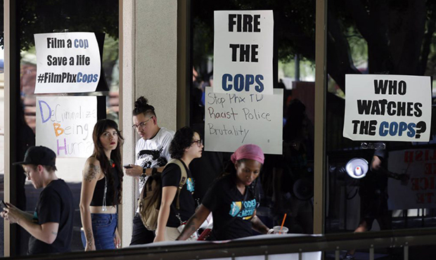 Protesters angered by a video of Phoenix officers who pointed guns and yelled obscenities at a blac...