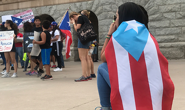 Dozens of Puerto Ricans living in metro Phoenix carry the island territory’s flag and signs at We...