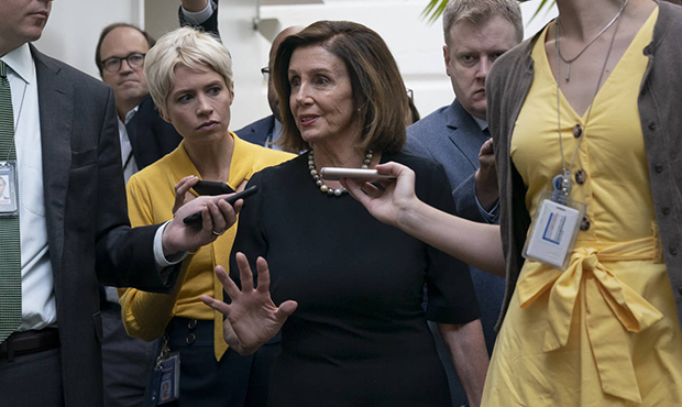 Speaker of the House Nancy Pelosi, D-Calif., is surrounded by reporters as she arrives to meet with...