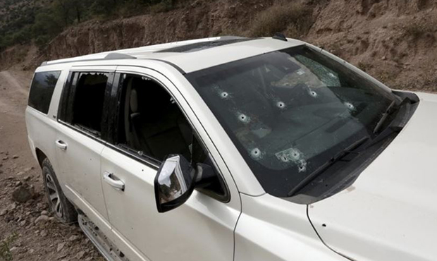 A bullet-riddled vehicle that members of LeBaron family were traveling in sits parked on a dirt roa...