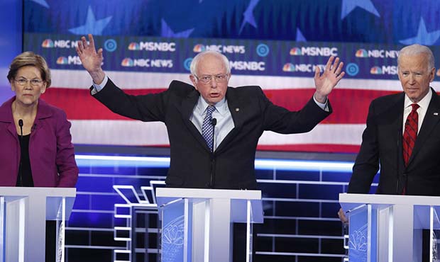 Democratic presidential candidate Sen. Bernie Sanders, I-Vt., speaks between Sen. Elizabeth Warren,...