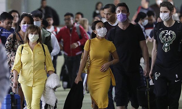 Passengers wear masks as they arrive at Manila's international airport, Philippines, Thursday, Jan....
