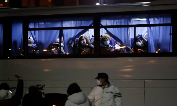 Buses carrying American passengers from the quarantined Diamond Princess cruise ship leave a port i...
