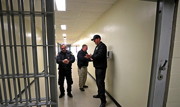 Correctional officers use alcohol hand sanitizer before entering the main cell block area at the Wo...