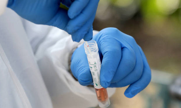 In this April 16, 2020, file photo, a medical worker places a swab in a vial while testing the home...