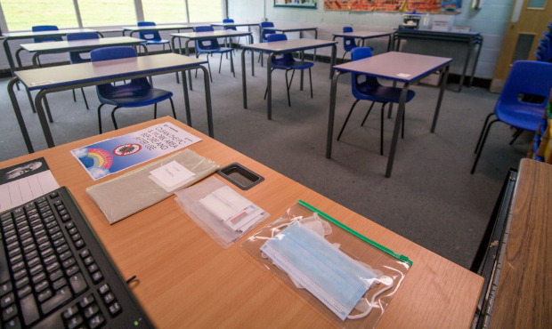 Spare face masks are seen on a teachers desk as a classroom is set out for social distancing at Lon...