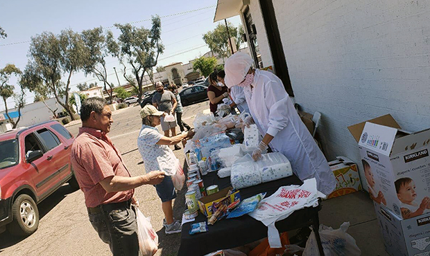 Volunteers with De Mujer a Mujer hand out food and supplies to  Phoenix families on April 11. The o...