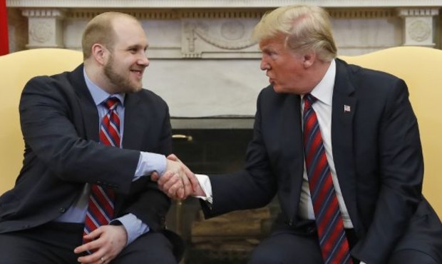 President Donald Trump shakes hands with Joshua Holt, who was recently released from a prison in Ve...