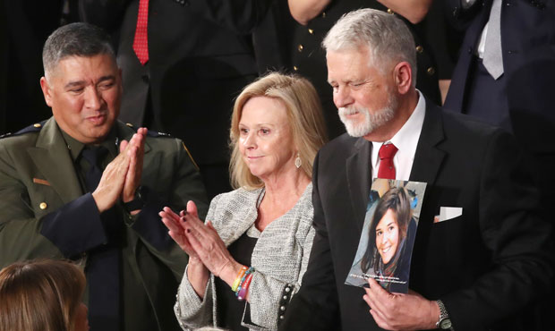 Carl Mueller (C) holds a photo of his daughter, Kayla, as his wife Marsha (L) looks on during the S...