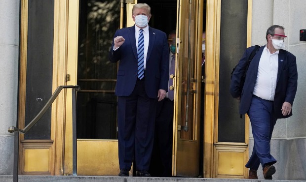 President Donald Trump walks out of Walter Reed National Military Medical Center to return to the W...