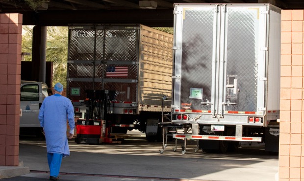 TUCSON, AZ - JANUARY 14: An employee walks towards refrigerated semi-trucks containing bodies at th...