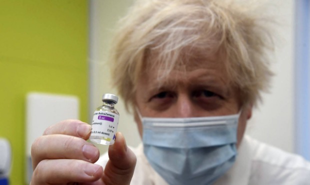 Britain's Prime Minister Boris Johnson holds a vial of the AstraZeneca vaccine during a visit to a ...