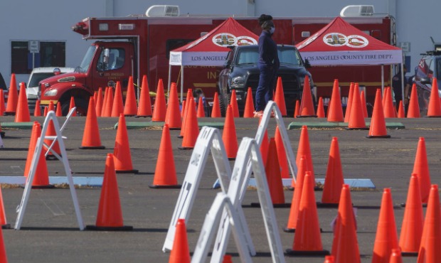 Health monitors at an "Observation Area" wait for motorists being inoculated with a COVID-19 vaccin...