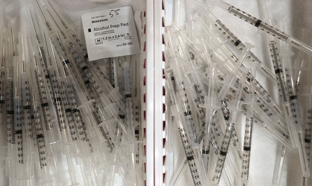 Syringes with doses of the Moderna COVID-19 vaccine are prepared for injection at First Baptist Chu...