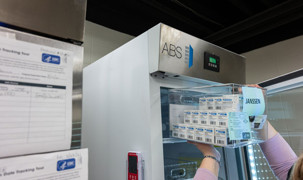 Janet Gerber, a health department employee, places Janssen COVID-19 vials in a refrigeration unit s...