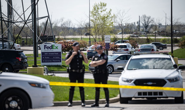 Police officers stand behind caution tape near a crime scene on April 16, 2021 in Indianapolis, Ind...