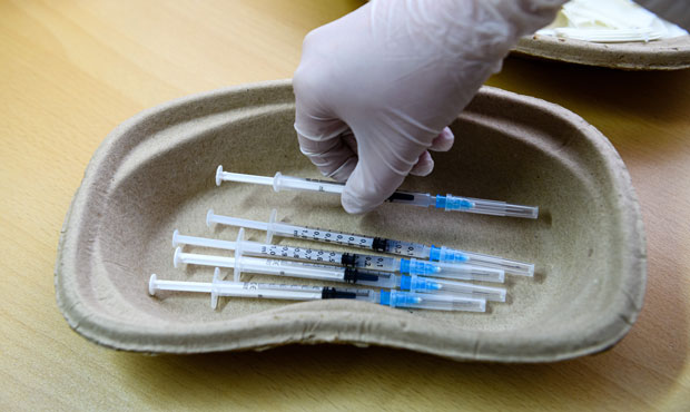 A doctor prepares syringes that contain the Pfizer/BioNTech vaccine against Covid-19 at a mobile va...