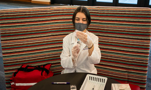 A pharmacist prepares doses of the Johnson & Johnson COVID-19 vaccine at a vaccination clinic on th...