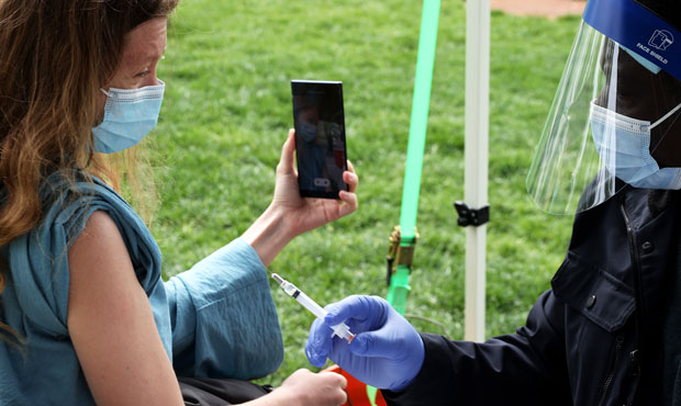A woman takes a selfie as she prepares to receive a dose of the Johnson & Johnson coronavirus vacci...
