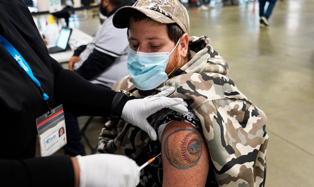 A baseball fan is given the Johnson & Johnson COVID vaccine in coordination with the Cook County He...