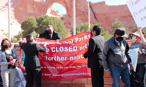 Navajo Nation officials remove a closure sign after allowing tribal parks to reopen at 50% capacity...