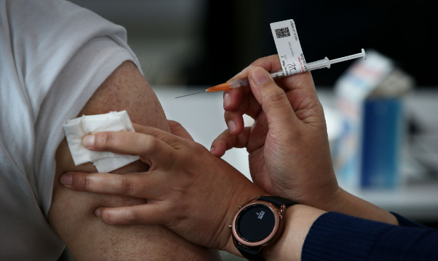 AUGUST 08: Registered Nurse Ririn Widiashi administers the Pfizer vaccine to a client at a pop-up c...