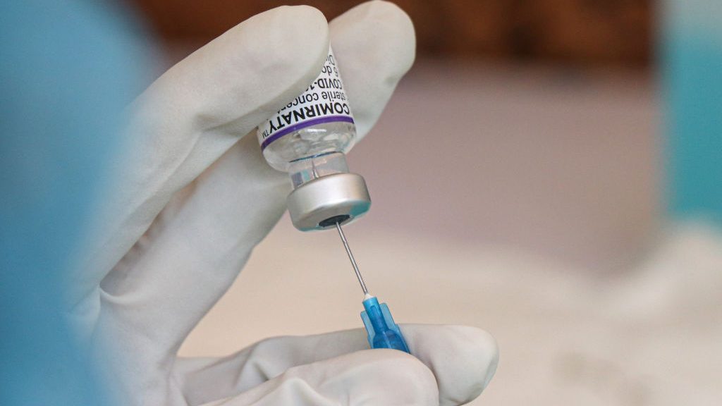A health worker extract pfizer covid-19 vaccine form a vial. Vaccination program at the Military Ho...