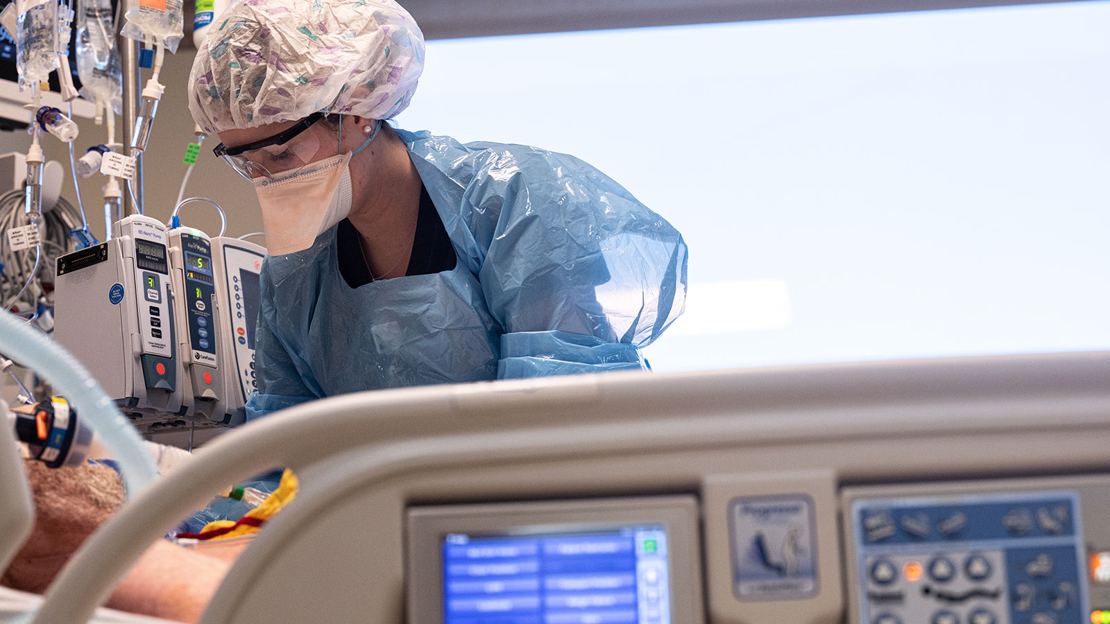 A health care worker tends to a patient on a ventilator in the Intensive Care Unit of Baptist Healt...