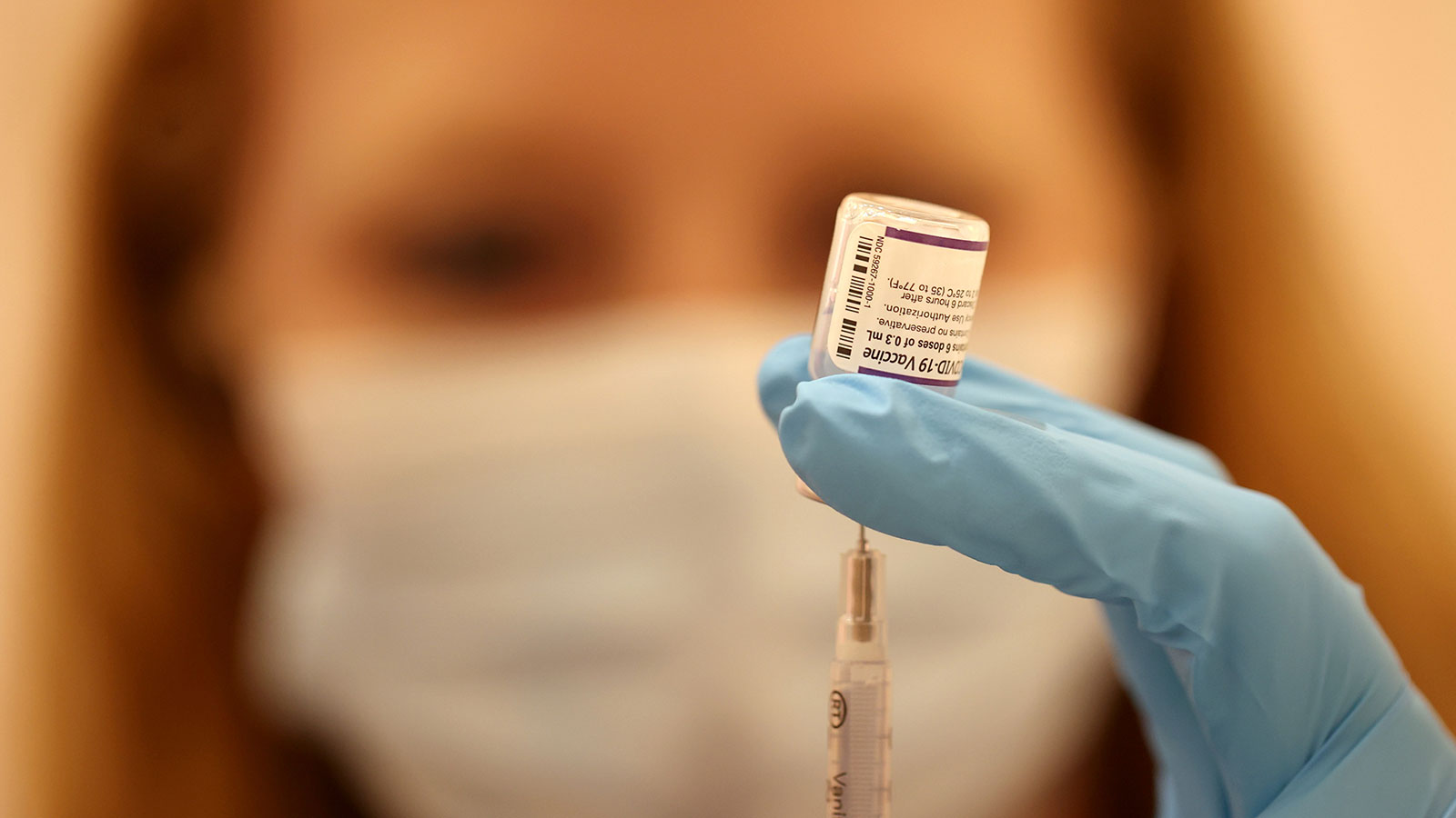 A pharmacist fills a syringe with the Pfizer COVID-19 booster vaccination at a vaccination booster ...