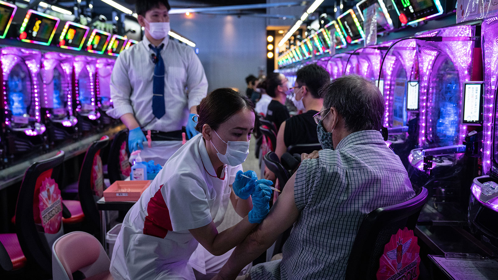 A man receives the Moderna coronavirus vaccination in a pachinko parlour on October 13, 2021 in Osa...
