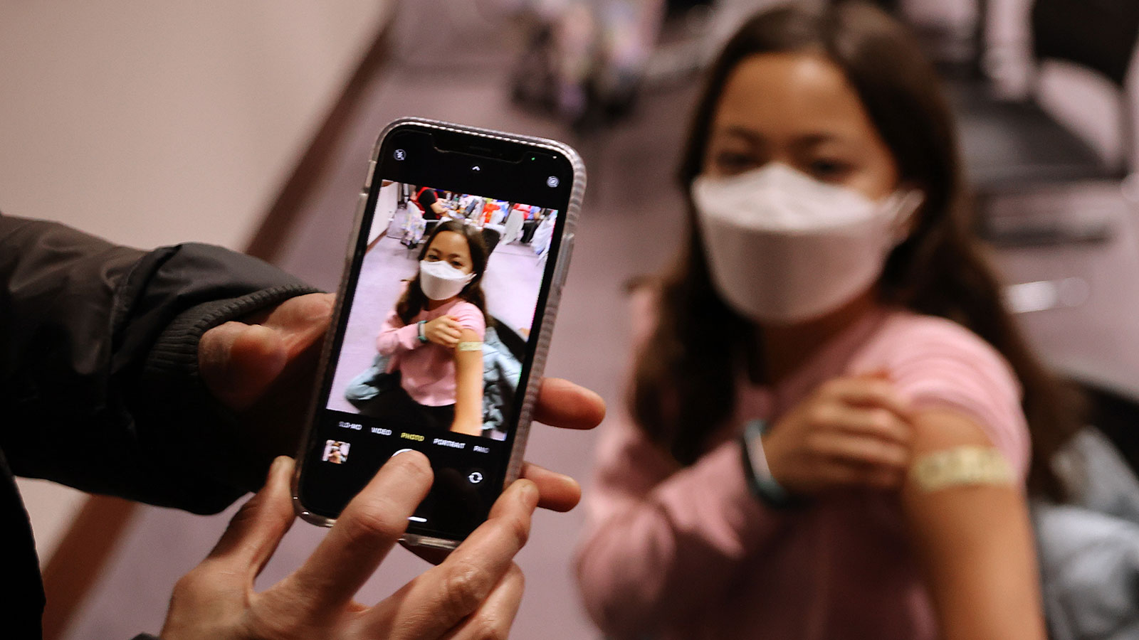 A girl poses for a photograph after receiving her first Pfizer BioNTech COVID-19 vaccination at the...