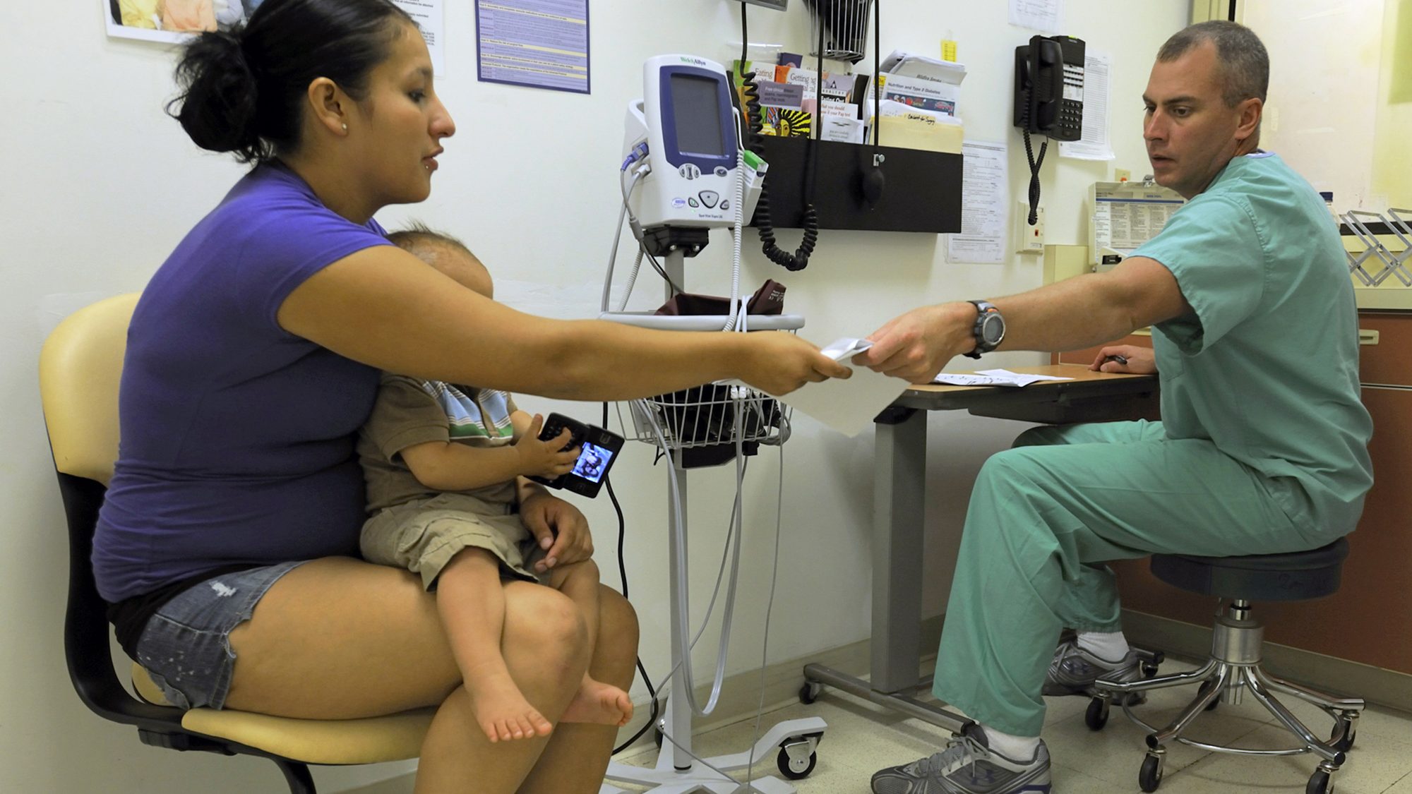 Oklahoma Army National Guard Sgt. Jim Croft consults with a patient during a routine checkup at the...