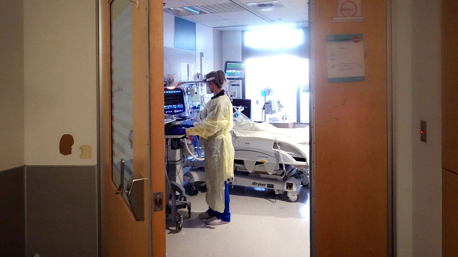 A respiratory therapist checks on a COVID-19 patient in the ICU at Rush University Medial Center on...